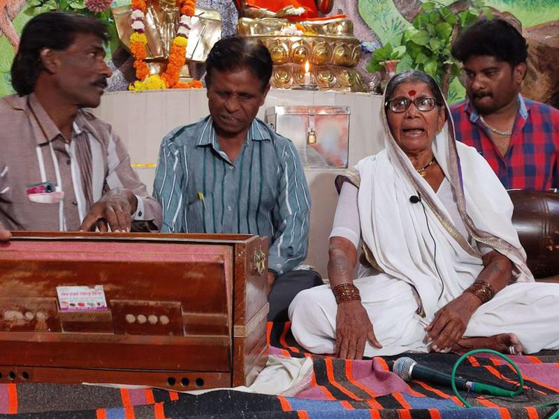 一位老妇人与三位乐手一起唱着反种姓歌曲